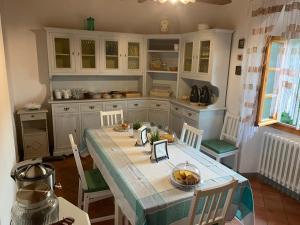 cocina con mesa y sillas en una habitación en B&B villa bianca, en SantʼAgata