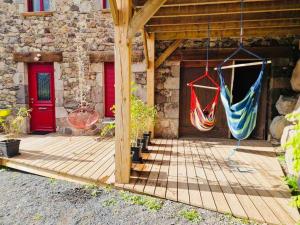 a patio with two hammocks hanging from a building at Chez Gaston in Chambon-sur-Lac