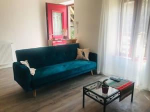 sala de estar con sofá azul y mesa en Chez Gaston en Chambon-sur-Lac