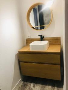 une salle de bain avec un lavabo et un miroir dans l'établissement Chez Gaston, à Chambon-sur-Lac 6 autres photos