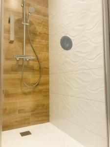 La salle de bains est pourvue d'une douche et d'un mur en bois. dans l'établissement Chez Gaston, à Chambon-sur-Lac