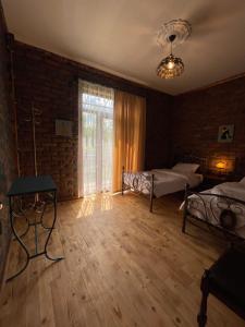 a large room with two beds and a window at Odo’s Guest House in Martvili