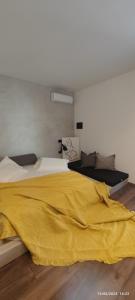 een slaapkamer met een gele deken op een bed bij Residence La Pineta in Golem