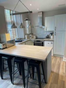 a kitchen with a large wooden table with stools at James St Park 2 bed Gr Flr, sleeps 4 in Helensburgh