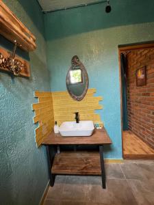 uma casa de banho com um lavatório e um espelho na parede em Odo’s Guest House em Martvili