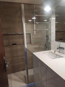 La salle de bains est pourvue d'une douche en verre et d'un lavabo. dans l'établissement Armação de Pêra, à Armação de Pêra