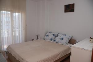 a small bedroom with a bed and a window at Apartman NAOMI in Zagreb