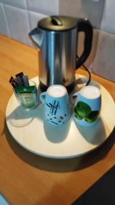 a plate with two cups and a pot on a table at Mary's apartment in Stomio