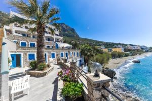 Blick auf einen Strand mit einem Gebäude und Palmen in der Unterkunft Ambiance Studios in Masouri