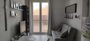 uma sala de estar com um sofá e uma grande janela em DolceVita Home em Civitanova Marche