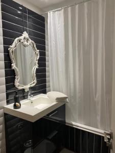 Le Patio Père Pigne Guestroom في بيربينيا: حمام مع حوض ومرآة
