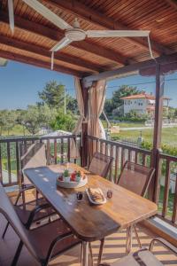 une table et des chaises en bois sur une terrasse avec vue dans l'établissement BS Village, à Metamórfosi