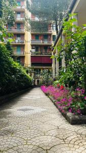 une route en briques devant un bâtiment fleuri dans l'établissement A casa di Marisa, à Rome