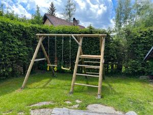 a playground with a ladder and a swing at Holiday house Lipno-Slupecna in Lipno nad Vltavou