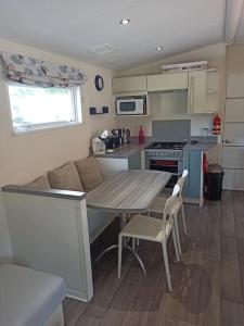 a kitchen with a wooden table and a table and chairs at Mobil-home FO 88 à VIAS in Vias