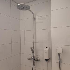 a shower with a glass door with a shower at Esplanad Suites in Mariehamn