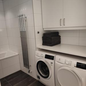 - une buanderie blanche avec lave-linge et sèche-linge dans l'établissement Esplanad Suites, à Mariehamn