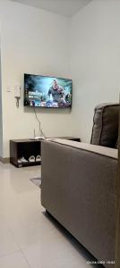 a living room with a couch and a flat screen tv at Shore 2 Tower 1 JMB Staycation in Manila