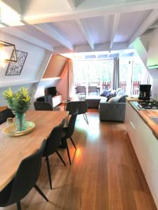 kuchnia i salon z drewnianym stołem i krzesłami w obiekcie Chalet Het Bosnestje Durbuy w mieście Durbuy