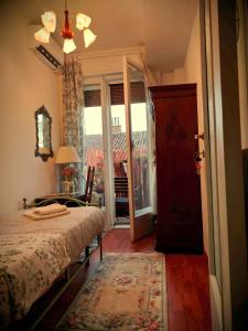 um quarto com uma cama e uma porta com uma janela em B&B I FILOKSENIA em Trieste