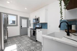a white kitchen with a sink and a refrigerator at Walking distance to JAGS Stadium & Downtown in Jacksonville