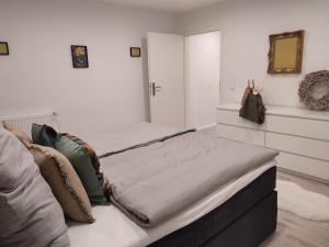 a white bedroom with a bed with pillows at Frankenholzer Ferienwohnung in Bexbach