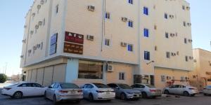 un grupo de coches estacionados frente a un edificio en Almalki furnished units, en Al Thybiyah