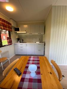 ÅnimskogにあるFurusjöns Cottageのキッチン(リモコン付きの木製テーブル付)