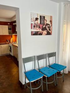two blue chairs in a kitchen with a picture on the wall at Casa Servus in Mamaia Sat/Năvodari