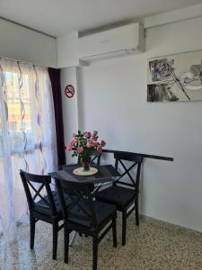 a black table with two chairs and a vase of flowers on it at BENALMADENA GAMONAL ÁGUiLA WONDERFUL AT HOME in Benalmádena +13 photos