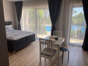 a bedroom with a bed and a table with a chair at Open Sea Residence in Byala