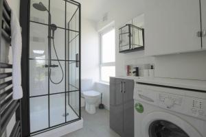 a bathroom with a washing machine and a toilet at StayRight Cosy Mezzanine Flat in Vibrant Area - Walking Distance to Central Cardiff in Cardiff