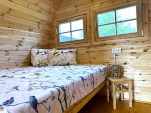 une chambre avec un lit dans une cabane en rondins dans l'établissement Vidusgrīvas, à Nida