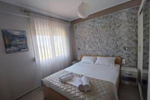 a bedroom with a bed with towels on it at A & F Apartments - Ari's house in Kalivia Poligirou