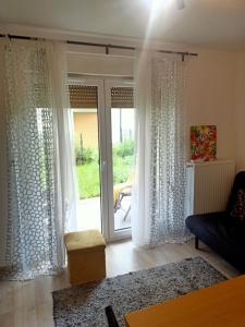 a living room with white curtains and a sliding glass door at Przytulne studio - 2 pokoje,parking,blisko centrum-6km,tramwaj, Nflix, park, spokój, in Wrocław