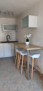a kitchen with a wooden table and some white chairs at Le Cygne, appartement de standing en hyper-centre in Sarreguemines