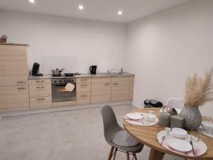 a kitchen with a wooden table with chairs and an oven at Frankenholzer Ferienwohnung in Bexbach