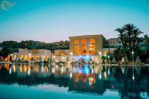 um resort com uma grande piscina em frente a um edifício em Djerba Castille em Aghīr