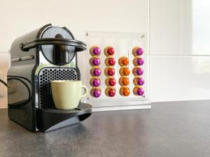 a coffee maker with a cup next to a box of donuts at Schöne Wohnung mit Rheinblick/Düsseldorf/Neuss/Messe in Neuss