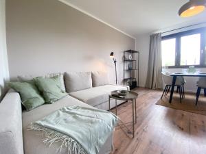 a living room with a couch and a table at Apartment mit Rheinblick, Messe, Balkon, Küche, Parkplatz in Neuss
