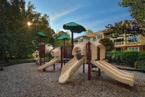 a playground with slides and umbrellas in a park at Marriott's Manor Club at Ford's Colony in Williamsburg
