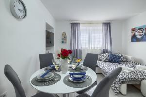 a living room with a white table and chairs at Studio apartman Luka in Pomer
