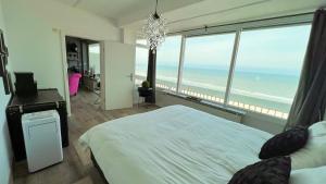 a bedroom with a bed and a view of the ocean at Ocean BreezeApartment: WakeUp 2 Sound of the Waves in Zandvoort