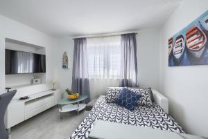 a bedroom with a bed and a table and a window at Studio apartman Luka in Pomer