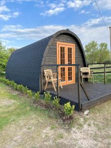 een koepelhuis met twee stoelen op een terras bij Vidusgrīvas in Nida