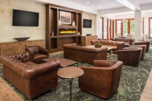 a living room with leather furniture and a flat screen tv at Four Points by Sheraton Santa Cruz Scotts Valley in Scotts Valley