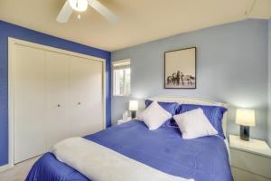 ein Schlafzimmer mit einem blauen Bett mit zwei Kissen in der Unterkunft Dog-Friendly Denver Vacation Home with Gas Grill! in Denver