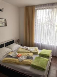 ソゾポルにあるАпартамент Хармонияのベッドルーム1室(ベッド2台、タオル付)、窓が備わります。