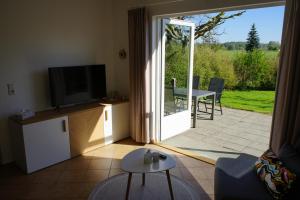 a living room with a tv and a sliding glass door at Klättes Ferienwohnung mit Garten in Zagelsdorf