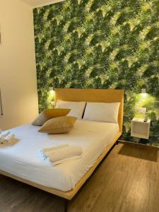 1 dormitorio con 1 cama con una gran pared verde en B&B Baia Del Salento, en Pulsano